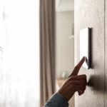 Joven usando un dispositivo táctil inteligente montado en la pared.