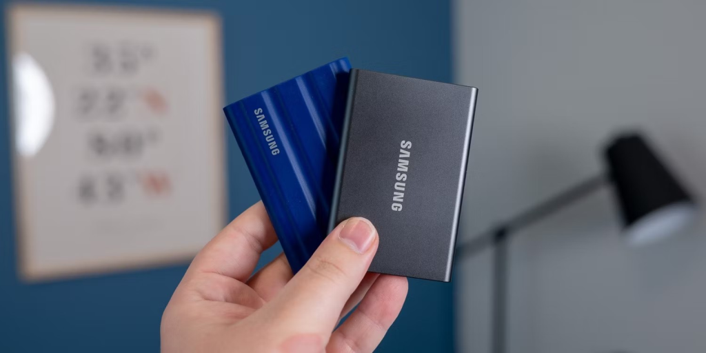 Una persona sosteniendo dos SSD portátiles Samsung